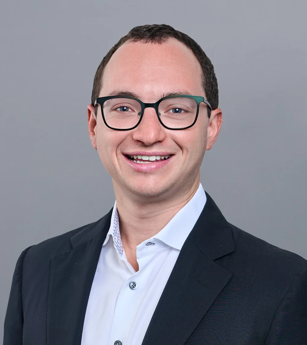 Smiling professional man with glasses in dark blazer