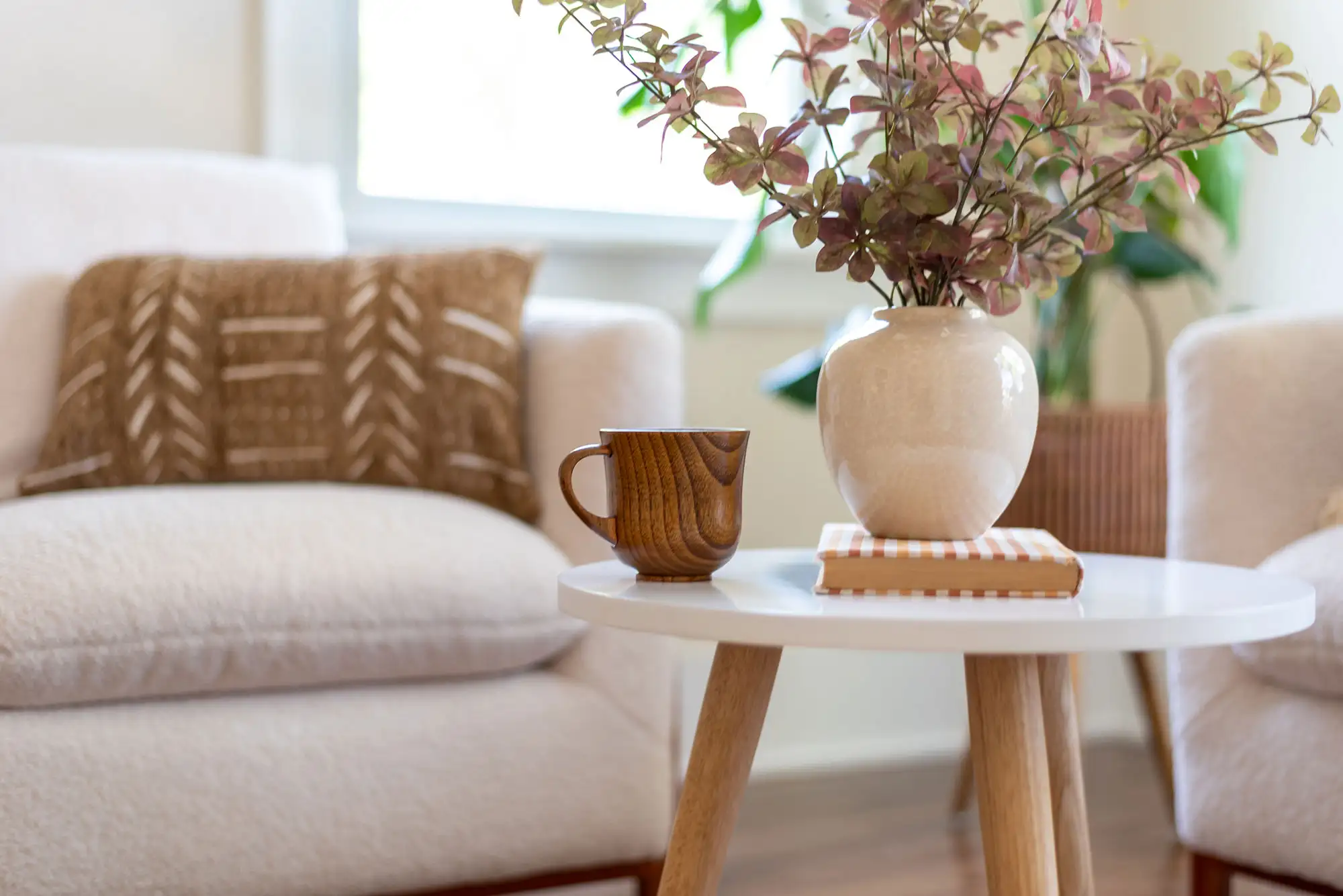 Cozy living room with white vase, wooden mug, and sofa
