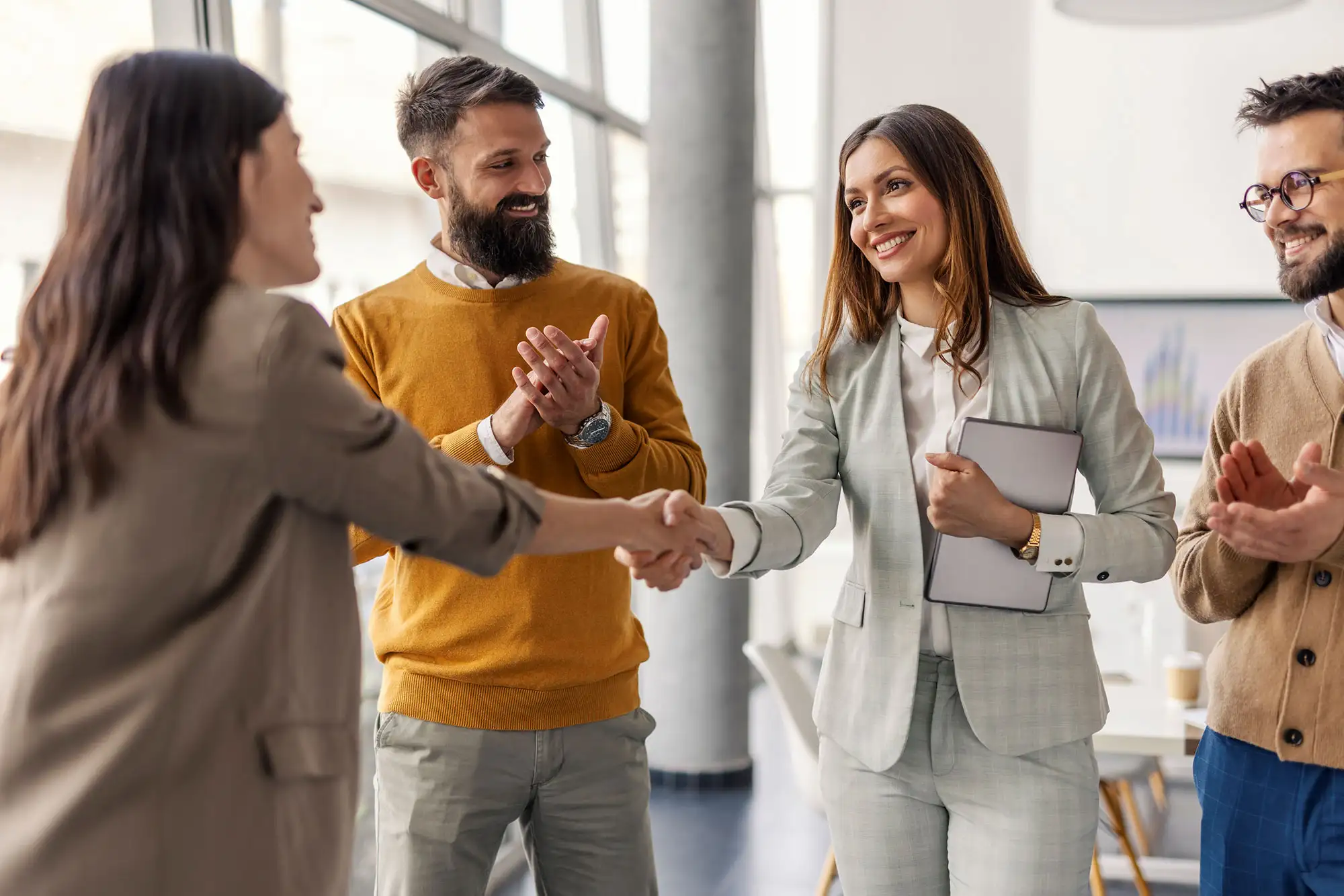 Business professionals shaking hands in a modern office setting