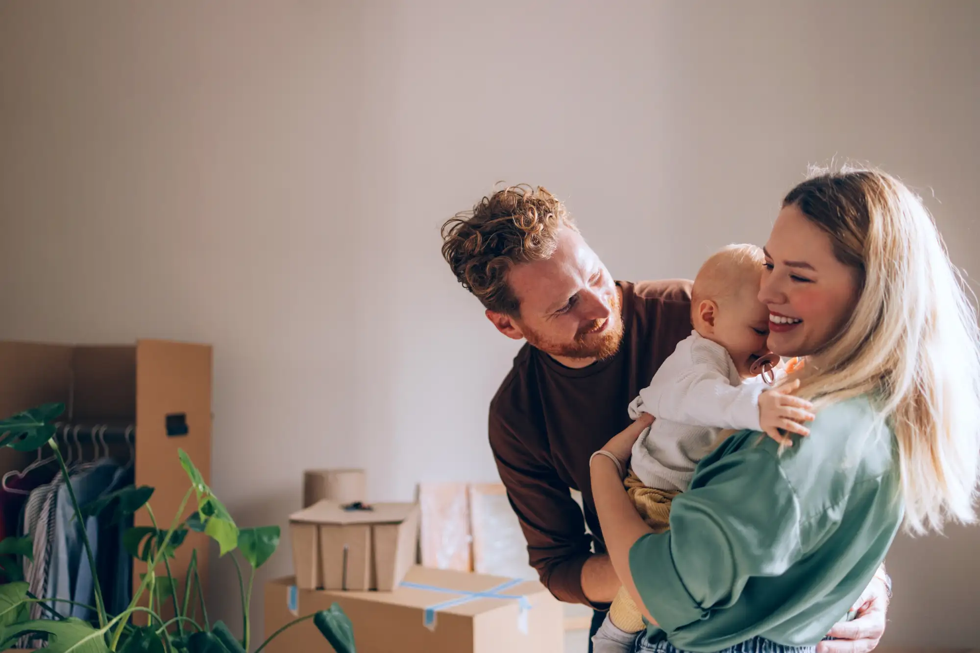 Happy young family with baby moving into new home