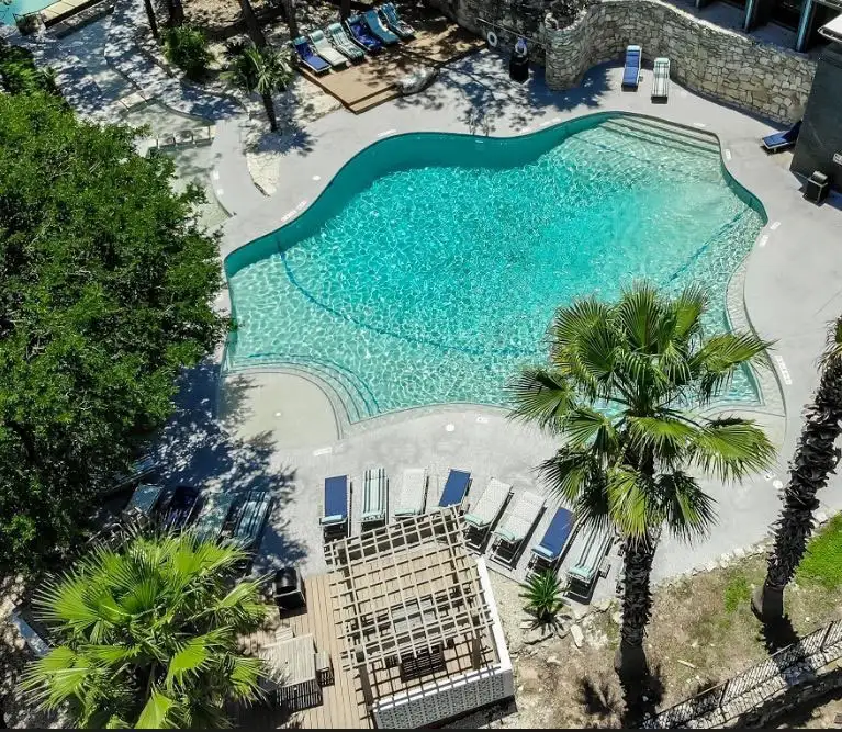 Aerial view of resort pool with palm trees and lounge chairs