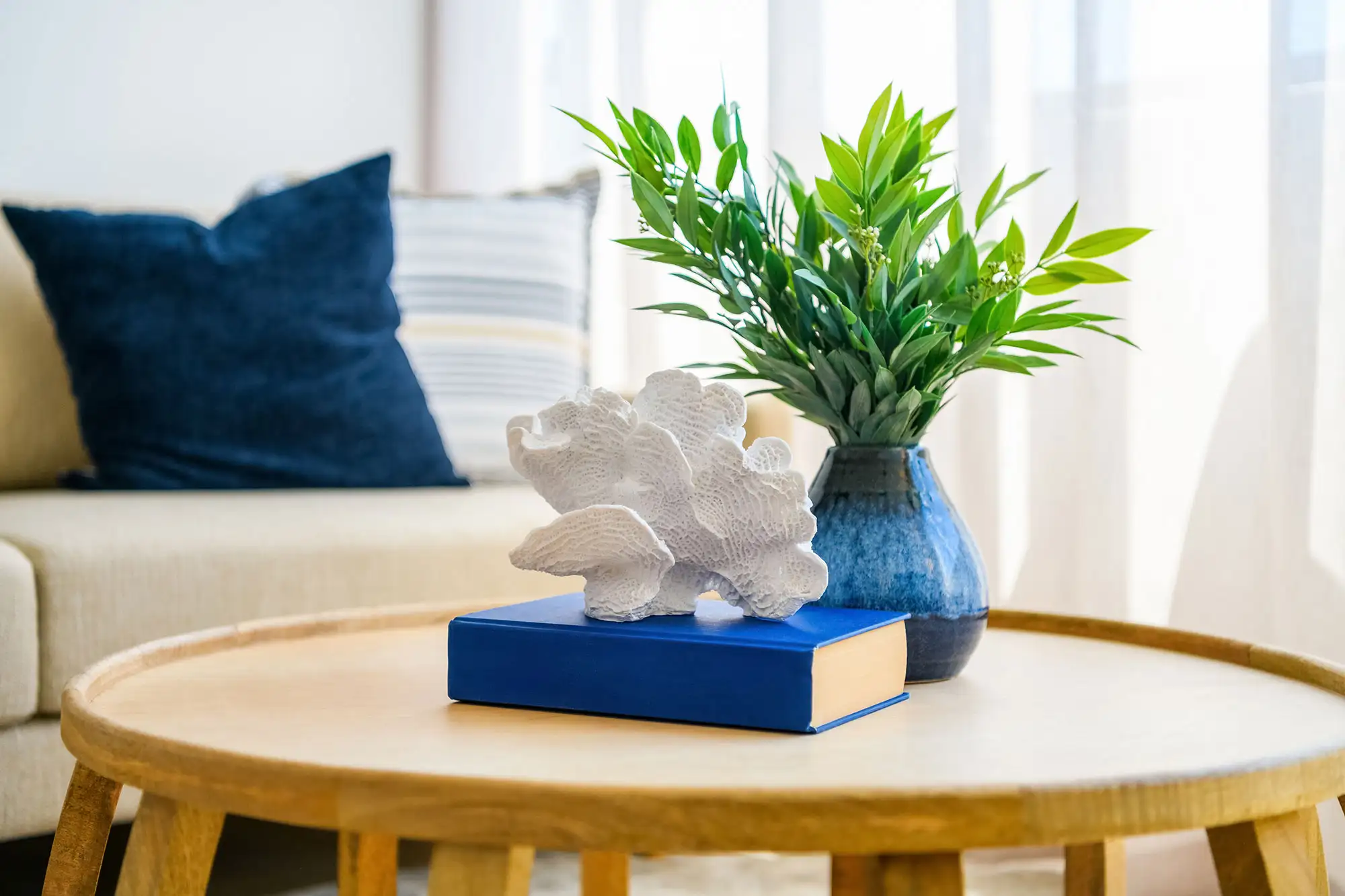 Coastal living room decor with coral, plant, and blue accents